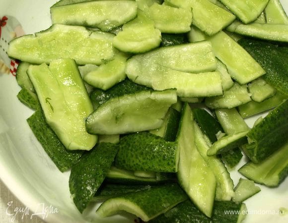 Огурцы отбить скалкой или большим ножом. Бейте без жалости, до хруста. Битые огурцы нарезать или поломать на несколько частей.  Складываем в миску. Добавляем соль и уксус. И оставляем мариноваться на 20 минут.