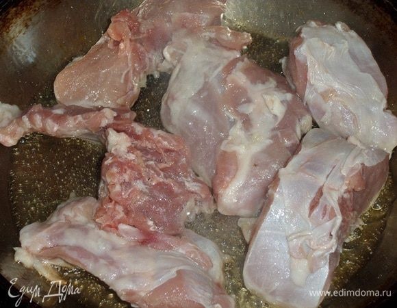 В раскаленную сковороду наливаем 3 ст. л. растительного масла. Выкладываем куски кролика.