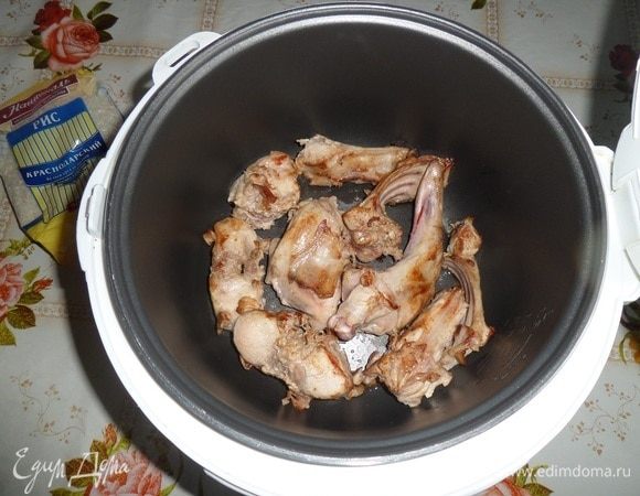 Куски обжаренного кролика выкладываем в чашу мультиварки.