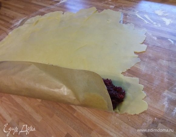 Выложить начинку и с помощью бумаги свернуть в рулет. 