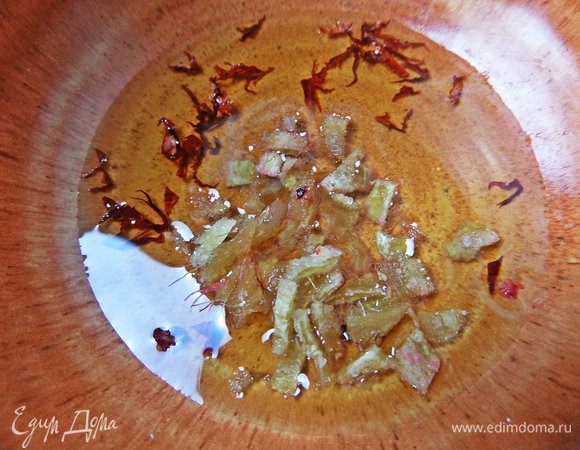 Для заправки в масло высыпать чили и измельченный имбирь.