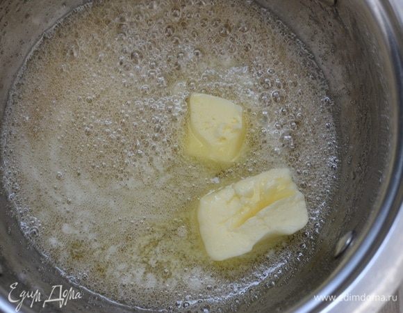 Снять с огня готовую карамель, добавить кусочками сливочное масло и перемешать до его растворения.
