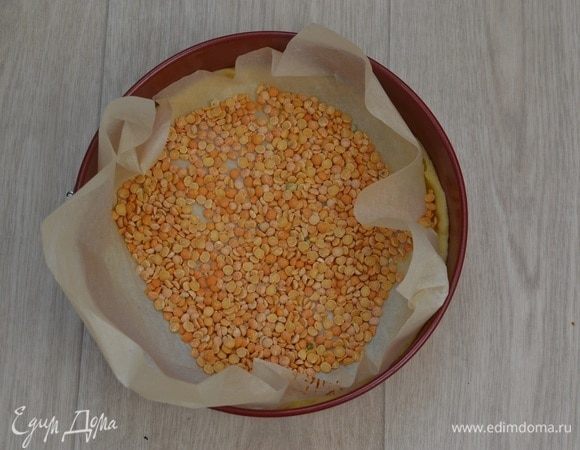 Дно наколоть вилкой, сверху положить пергамент с грузом (любые бобовые), выпекать в разогретой духовке при 180°С 10 минут, затем снять груз вместе с бумагой и выпекать еще 10 минут. Дать остыть.