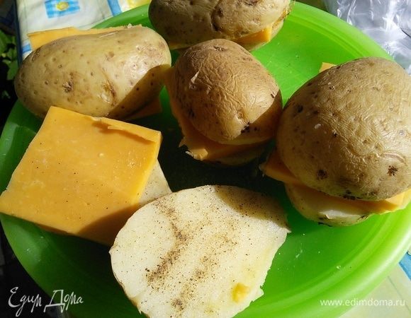 Вареный и остывший картофель разрезать на половинки. Посолить (с учетом солености сыра и бекона) и поперчить. Проложить пластинками сыра. Сыр выбирайте на ваш вкус, пластинки желательно брать потолще. 