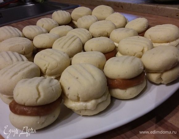 Половину печенья смазать с плоской стороны кремом, соединить со второй половиной, поставить на полчаса в холодильник. 