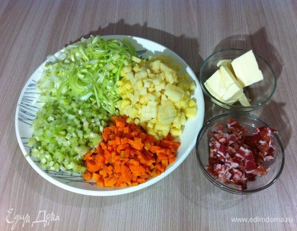 Нарезать мелким кубиком овощи: сельдерей, морковь и картофель. Тонко нашинковать полукольцами лук-порей. Нарезать небольшими кубиками бекон.