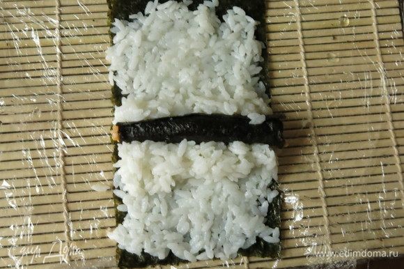 Цилиндрик риса формируем в виде листка — один край делаем острым. В центре нори кладем цилиндр цветного, тыквенного риса, закрепляем его рисом.