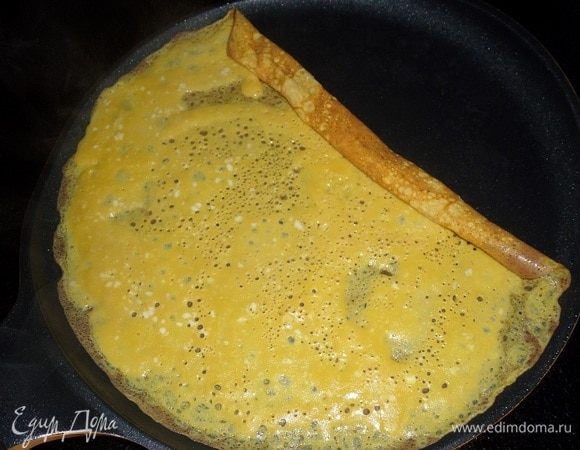 Как только смесь схватится, лопаткой сворачиваем омлет в рулет.