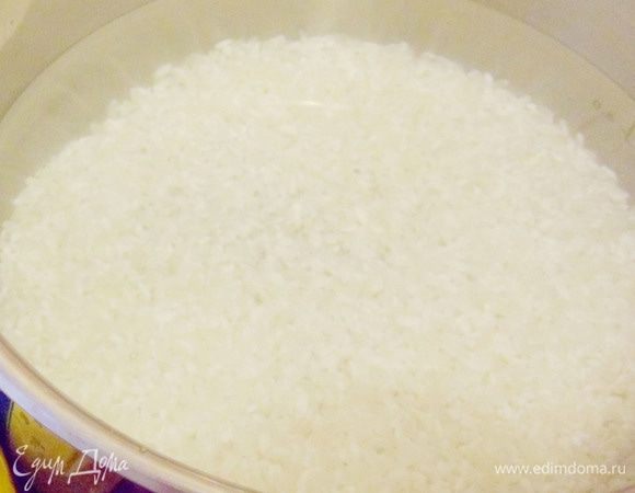 Рис промыть теплой водой дочиста, затем залить холодной водой, оставить выстаиваться на время около 2 часов. Затем воду слить. Залить рис 1,5 стаканами свежей холодной воды.
