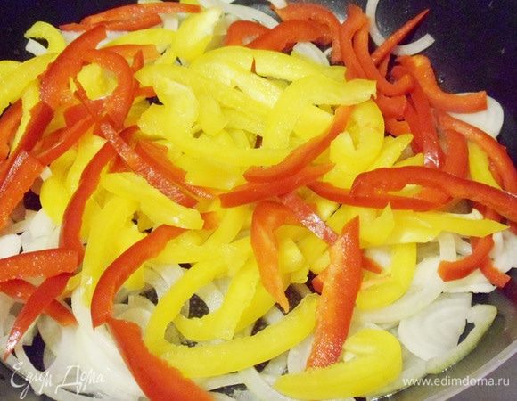 В одной сковороде разогреть одну столовую ложку растительного масла и обжарить лук с перцем около 8 минут.