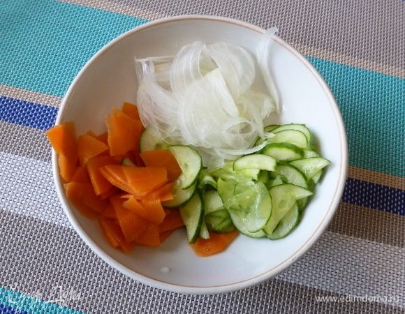 Свежий огурец нарежем тонюсенькими четвертинками, посолим и оставим в дуршлаге, чтобы стекала жидкость. Сладкий и сочный лук нарежем полупрозрачными перьями. Морковь нарезать четвертинками и слегка приварить. Морковь должна остаться с хрустинкой. 