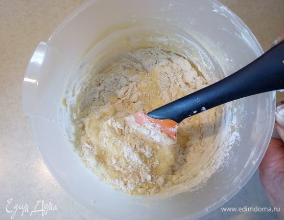 Добавить размягченное сливочное масло и снова взбить. Затем добавить просеянную муку, смешанную с разрыхлителем и цедрой половинки лимона.