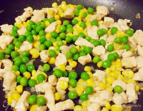 Затем добавить зеленый горошек и консервированную кукурузу. Готовить 2-3 минуты при постоянном помешивании.