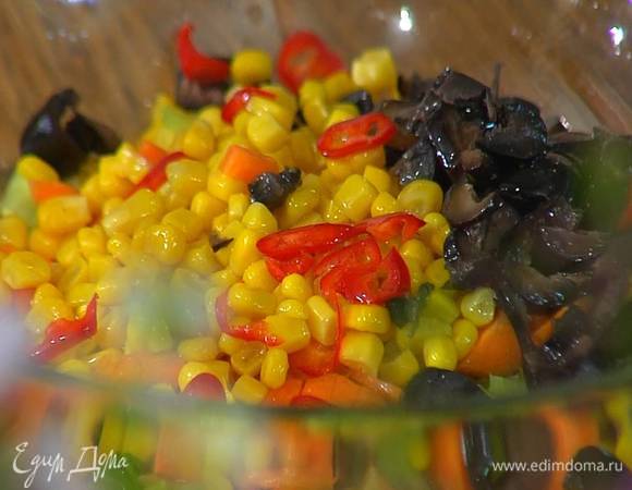 В глубокой салатнице соединить огурцы, сладкий перец, сельдерей, морковь, маслины, консервированную кукурузу и перец чили, полить оливковым маслом, апельсиновым соком, добавить пасту тахини, все посолить и перемешать.