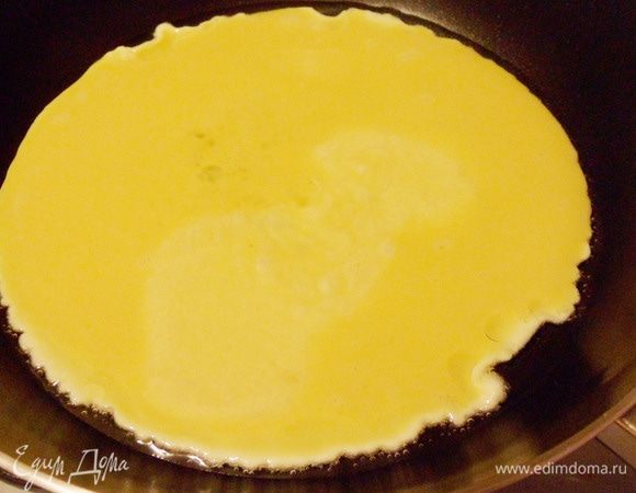 Нагреваем растительное масло в сковороде, вливаем половину яичной смеси (один стаканчик), быстро и аккуратно мешаем, чтобы получить однородную консистенцию и ждем, пока омлет схватится. 