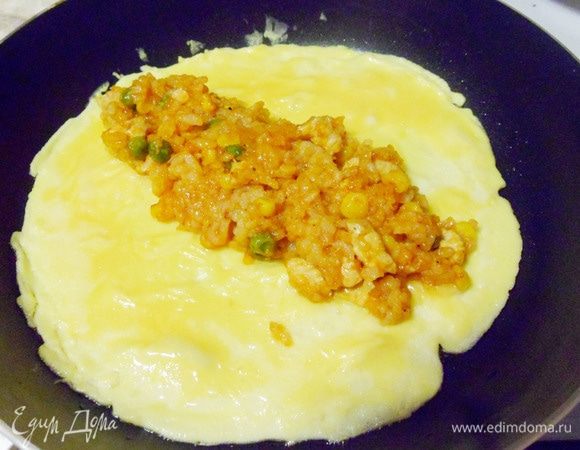 Когда омлет схватился, выложить в центр рисовую начинку.