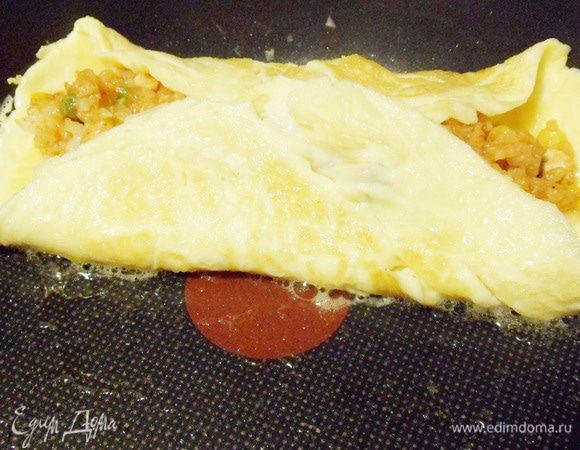 Потом завернуть другой край. Накрыть сковороду тарелкой и быстро перевернуть омлет на тарелку.