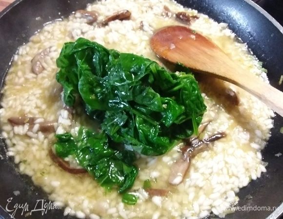 Когда рис будет готов (процесс продолжается примерно около 20 минут, рис не должен развариться и превратиться в кашу, а иметь в серединке плотноватую консистенцию. Добавить шпинат (у меня предварительно размороженный), прогреть. Шпинат готовится быстро, размешать.