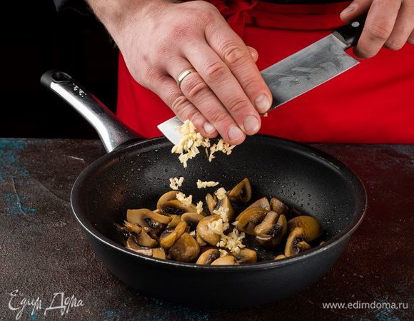 Нарежьте крупно грибы и обжарьте на оливковом масле до румяной корочки. К горячим грибам добавьте измельченный чеснок.