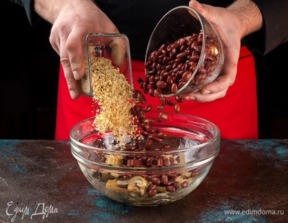 Нарежьте крупно орехи. Добавьте к обжаренным овощам. Добавьте фасоль.