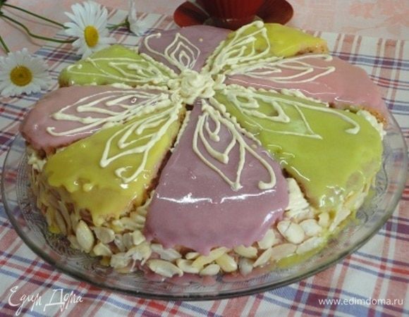 Нижний корж промочить пропиткой и смазать кремом, накрыть вторым коржом, пропитать и смазать оставшимся кремом верх и бока. Бока украсить листочками миндаля. Сверху уложить части верхнего коржа. Посуду с глясажем освободить от пленки и слегка разогреть в микроволновке импульсами по 10-15 секунд, пробить блендером до однородной массы и покрыть лепестки верхнего коржа. Я делала это в несколько приемов, всякий раз помещая торт в холодильник для закрепления гляссажа. Согласна, что я не совсем по инструкции делала все манипуляции с украшением гляссажем, не выровняла предварительно «лепестки». Но делала я это не на заказ, а для себя. Вкус от этого не пострадал. Остатками крема украсить лепестки.