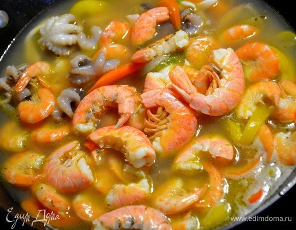 Выложить подготовленные морепродукты в кипящий бульон, перемешать, закрыть крышкой и варить 2 минуты (отсчет времени после закипания бульона). Добавить томатную пасту, перемешать и варить еще минуту. Вместе с томатной пастой в суп еще добавляют белое сухое вино примерно полстакана. Мой суп ели дети, поэтому я алкоголь не добавляла. 
Накрыть крышкой и дать настояться 5-10 минут.
