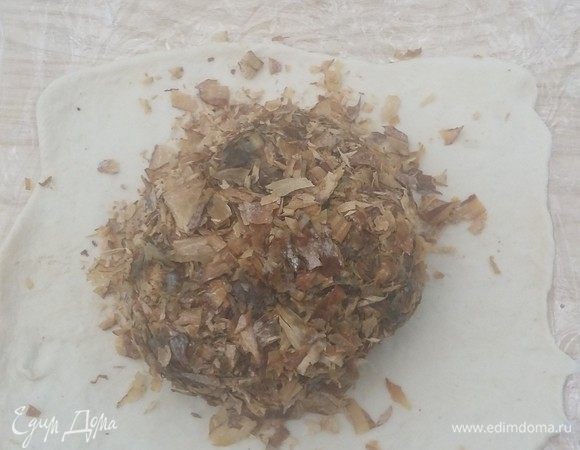 На лист пергамента или пленки разложить необходимый размер теста. Слегка раскатать.  Положить в середину мясо. 