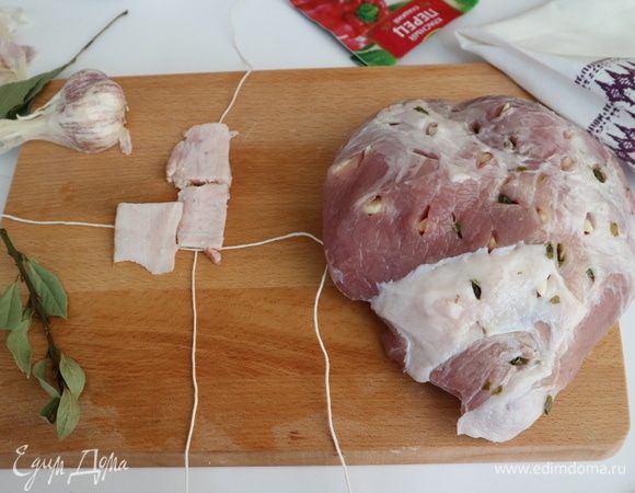 Грудинку (можно бекон) нарезать тонкими ломтиками. Чеснок порезать вдоль, нашинковать мясо чесноком, так же поступить с маринованными каперсами. Положить кулинарную нить крест накрест, сверху нити положить кусочки грудинки или бекона. 