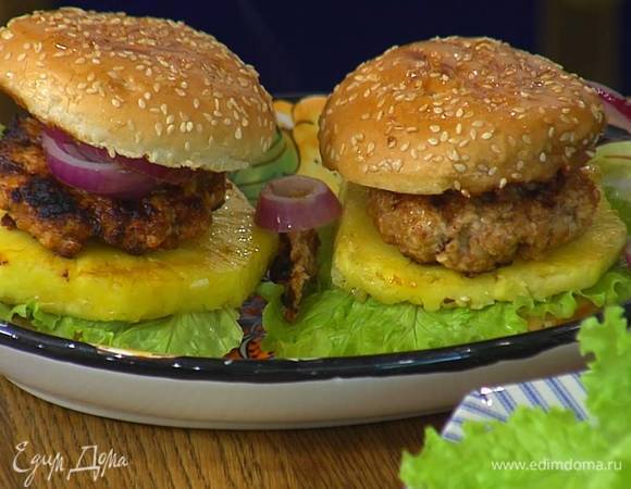 На нижние половинки булок поместить листья салата, кольца ананаса, затем котлеты, лук и накрыть все верхними половинками булок.