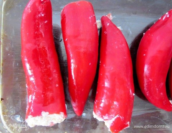 Начинить перцы начинкой. Духовку разогреть до 200°С. Выложить фаршированный перец на противень в один ряд, сбрызнуть оливковым маслом и запекать в течение 20-30 минут. 