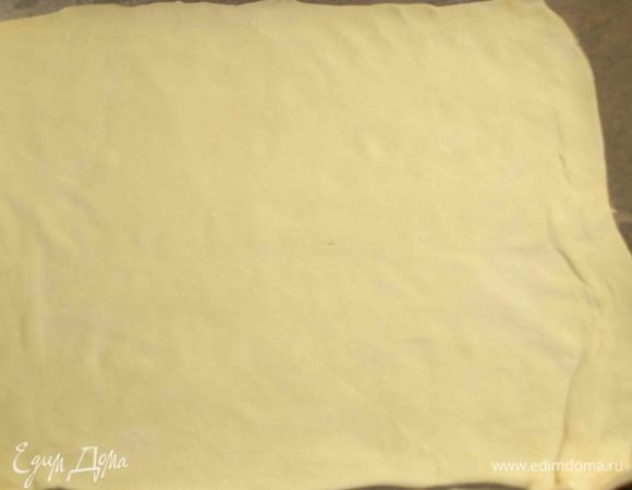 Большую часть раскатываем на поверхности припыленной мукой. На противень застелить пекарскую бумагу, смазать растительным маслом. Выложить раскатанный пласт.