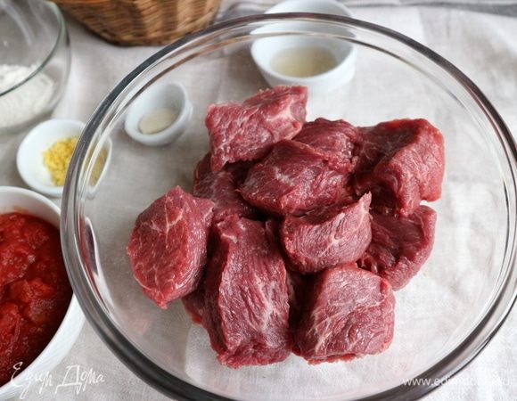 Нарезать мясо крупными кубиками. Натереть цедру половинки лимона на мелкой терке. Чеснок почистить.