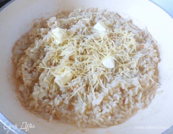 В готовое ризотто добавить сливочное масло, сыр и хорошо перемешать. Приправить по вкусу солью и перцем. Если ризотто слишком сухое,  добавить еще 0,5 половника бульона и подождать, пока он чуть впитается в рис. 