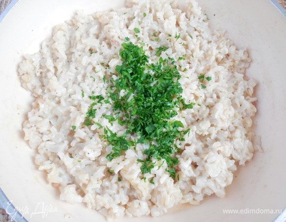 В самом конце вмешать в ризотто нарубленную петрушку. Ризотто выложить тонким слоем на противень или большую тарелку, накрыть пищевой пленкой в контакт и убрать в холодильник на 1 час (или на ночь) для остывания. 