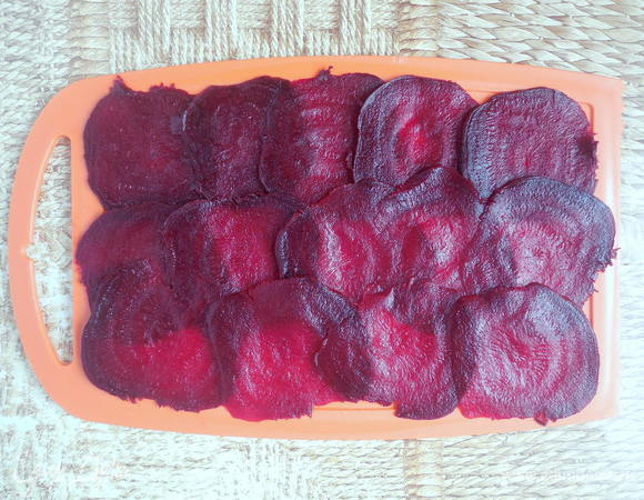 Духовку разогреть до 180°С. Остывшую свеклу очистить и нарезать тонкими слайсами при помощи специальной терки или вручную острым ножом. 