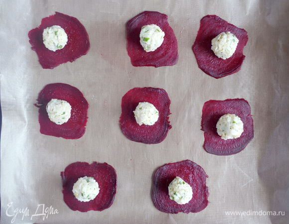 Теперь приступим непосредственно к сборке равиоли. Из указанного количества ингредиентов их получается 24 шт. Несколько слайсов свеклы выложить на противень, застеленный смазанной бумагой для выпечки или специальным ковриком. Приправить свеклу солью и перцем. На каждый слайс свеклы выложить по ½ ст. л. ризотто и слегка расплющить начинку.
