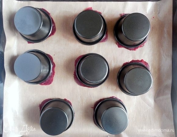 Чтобы при выпечке свекольные слайсы не загнулись кверху, их нужно прижать перевернутыми формочками для маффинов. В таком виде нужно запекать равиоли в течение 15 минут.