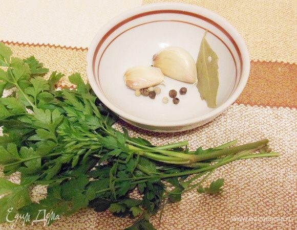 После чего добавить чеснок, разрезанный пополам, смесь перцев, лавровый лист. Зелень петрушки и укропа можно положить целиком, предварительно хорошо промыв их водой. Варить еще около получаса.