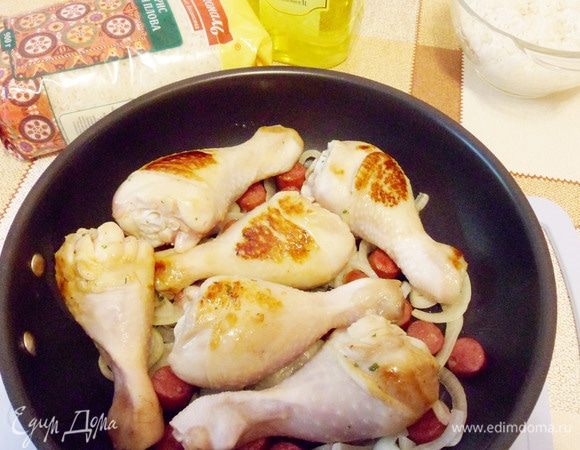 Переложить в общую сковороду к обжаренным луку и колбаскам.