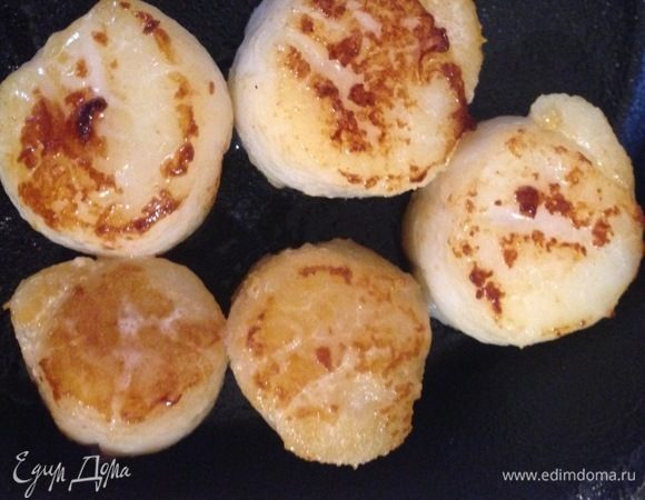 Гребешки разморозить, обсушить бумажным полотенцем и быстро обжарить с обеих сторон до золотистого цвета. Убрать на тарелку, накрыть и держать в тепле.