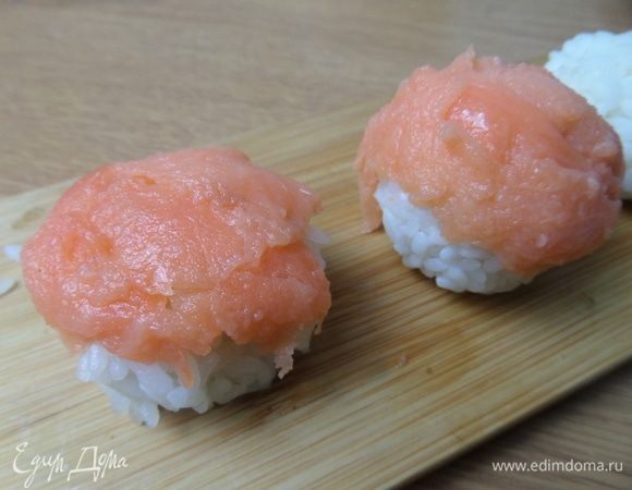 Первый вариант подачи: сделать ямку и вложить кусочек рыбки или креветку, но тогда внешне это будет просто рисовый шарик. Решала взять подачу: рыбка сверху.