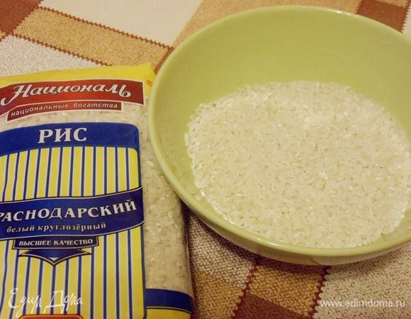 Пока тесто подходит, есть время заняться приготовлением риса для начинки. Круглозерный рис промыть несколько раз холодной водой, затем несколько раз горячей и переложить в кипящую соленую воду. Чтобы рис получился рассыпчатым, воды надо взять в 7-8 раз больше, чем риса. Во время варки рис нужно несколько раз помешать.