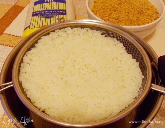 Готовый рис откинуть на сито, чтобы стекла вода. Промыть горячей водой. 
