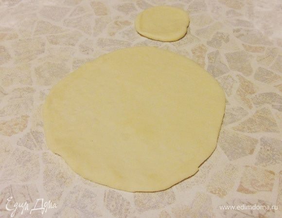 Большую часть раскатать в круг, размером с чайное блюдце. Маленькую часть тоже раскатать в кружок.