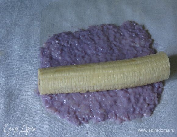 Кладем банан, отступив от края риса.