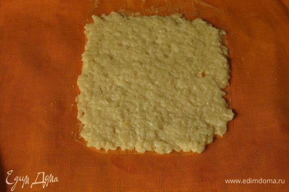Еще на один кусочек рисовой бумаги кладем белый рис, оставляя с краю пару сантиметров без риса.