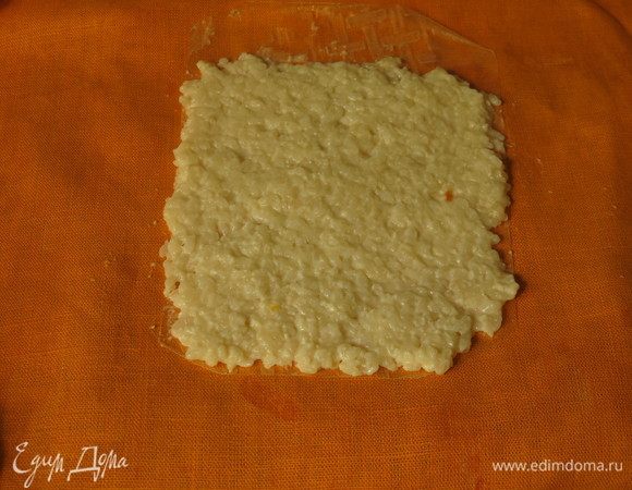 Еще на один кусочек рисовой бумаги кладем белый рис, оставляя с краю пару сантиметров без риса.