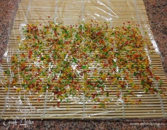 Циновку для суши выстлать пищевой пленкой и посыпать кокосом. Цветным или белым, решать вам. Можно использовать и орехи или шоколад.