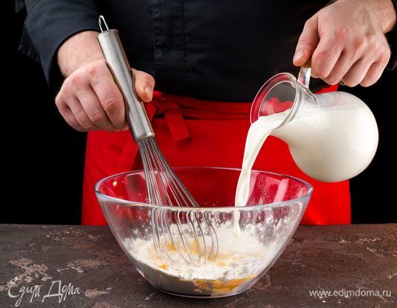В полученную смесь тонкой струйкой влить молоко, помешивая тесто. 
