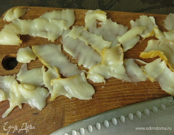 Нарезаем тонко кальмаров, полоски должны просвечиваться. У меня, к сожалению, очень тонкий пласт, полосы получаются узкими, большой расход продукта.